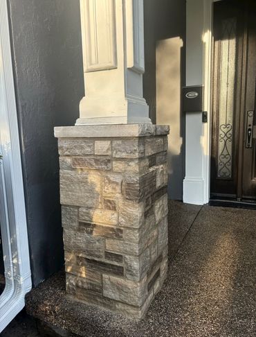 Stone pillar base supporting a column near a door.