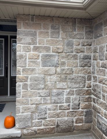 Stone wall with a pumpkin on the doorstep.