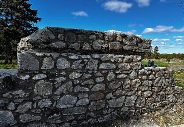 Old stone wall under clear blue sky.