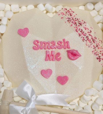 A heart-shaped lollipop with "Smash Me" written in pink and surrounded by marshmallows.