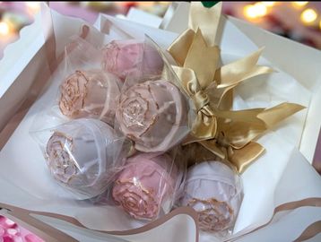 Elegant bouquet of pastel-colored chocolate roses wrapped with gold ribbons.