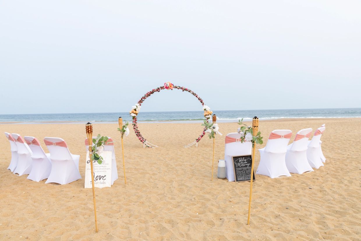 A beautifully decorated wedding ceremony space featuring a wedding arch adorned with flowers. 