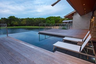 a huge swimming pool and two chairs for relaxing 