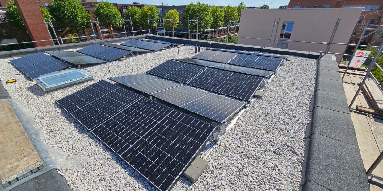 Solaranlage auf einem Kiesdach bei Sonnenschein.