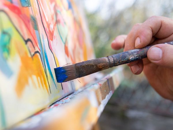 Close-up of an artist- painter working on painting in studio 