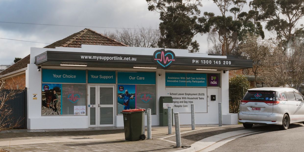Support center building with signage and a parked van.