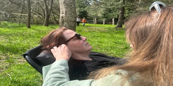 A woman relaxing outdoors wearing sunglasses.