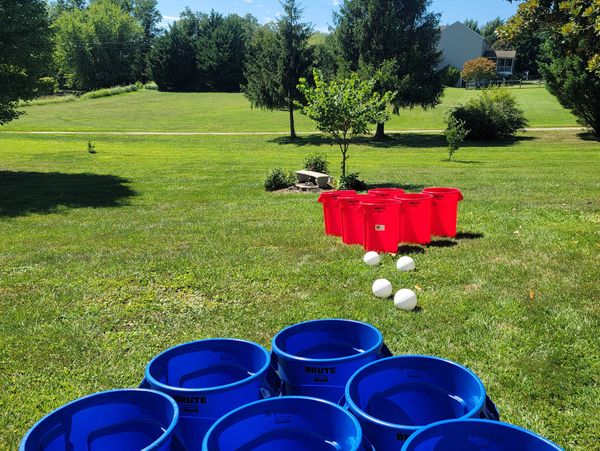 Some colorful buckets with some white balls in ground