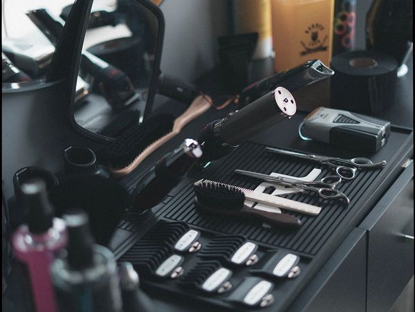 Barber shop equipment set isolated on black table background. Close up scissors, comb, brushes