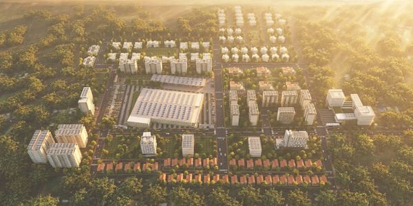 Aerial view of a modern residential and commercial complex surrounded by greenery.