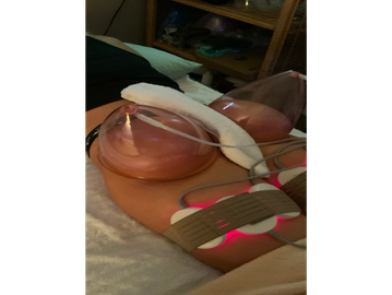 Woman undergoing LED light therapy on her abdomen.
