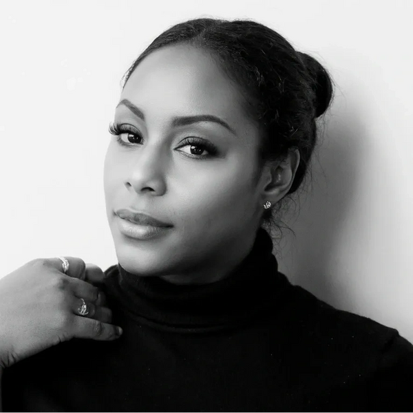 Elegant woman in a black turtleneck poses against a white background.