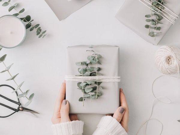 Girl's hands hold a gift box with minimalist style wrapping design