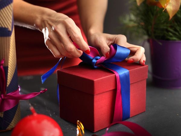Gift wrapping. Woman wraps presents, step by step
