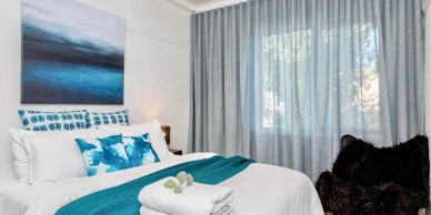 Cozy bedroom with teal accents and soft natural light.