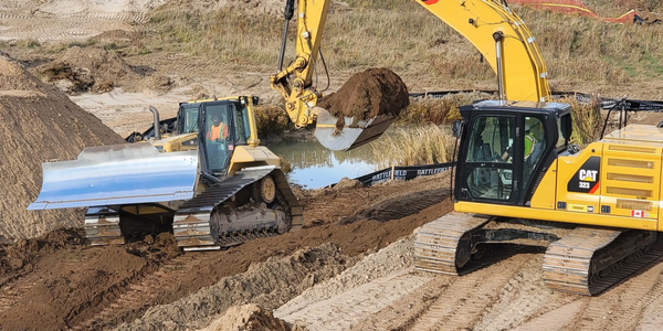 Excavator and bulldozer working together