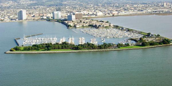 Aerial view of a marina with boats and cityscape in the background.