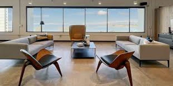 Modern living room with stylish furniture and large windows.