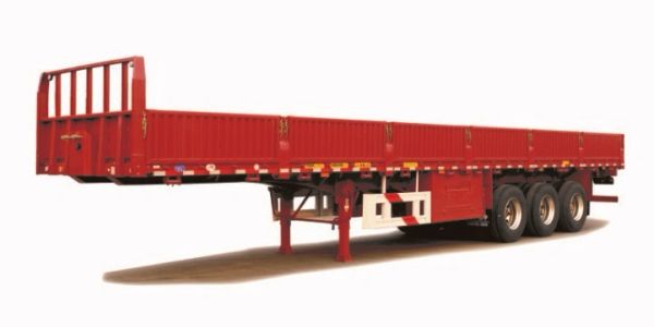 Red flatbed trailer with three axles and support legs.