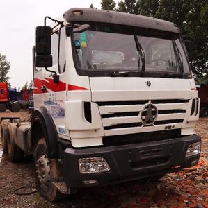White and red heavy-duty truck parked on a rough surface outdoors.