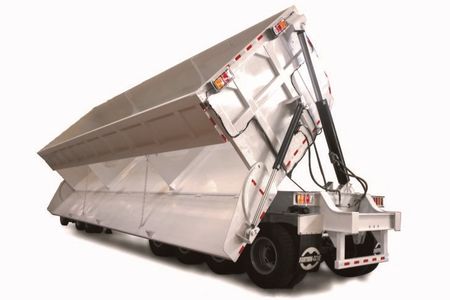Large industrial dump trailer with raised bed for unloading.