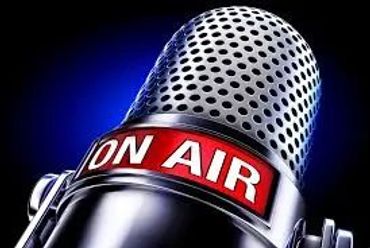 Close-up of a microphone with an 'ON AIR' sign.