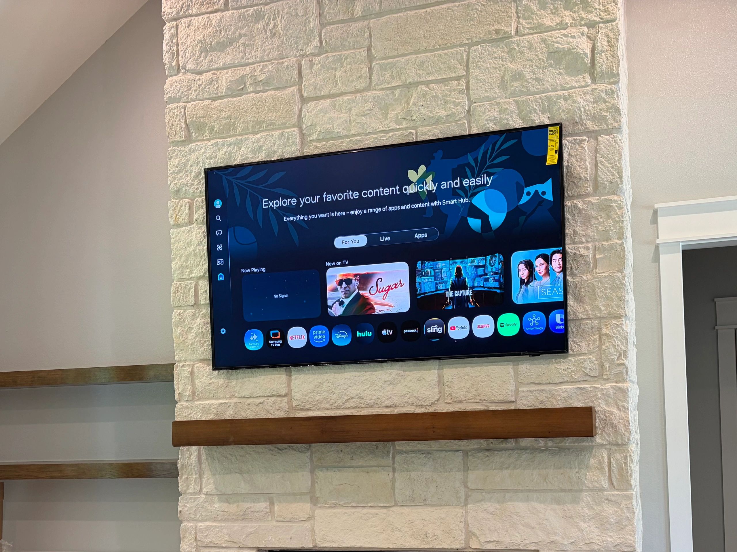 Wall-mounted TV with a stone background.