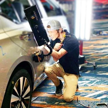 PDR technician fixing car dent