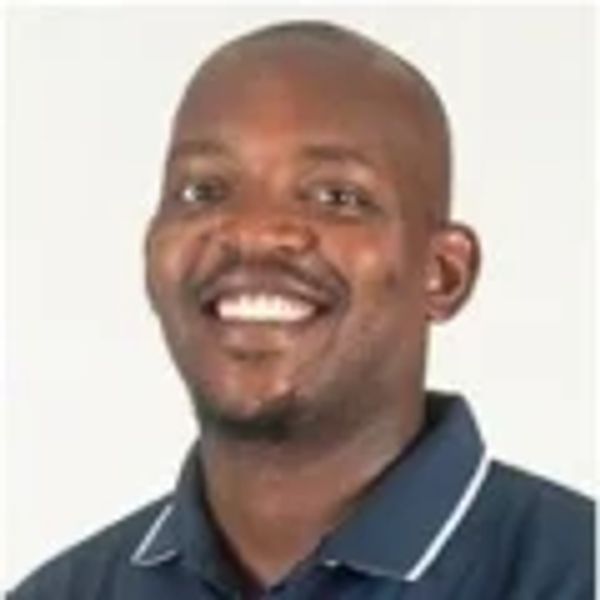 Smiling man in a navy blue shirt.