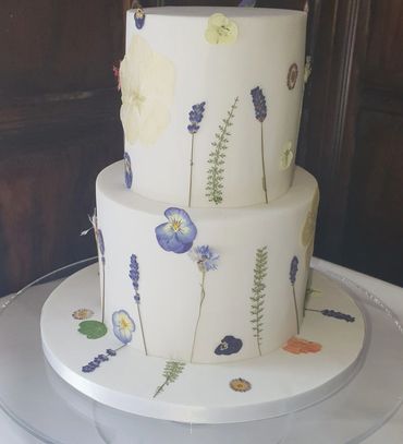 2 Tier fondant covered wedding cake decorated with edible dried flowers.