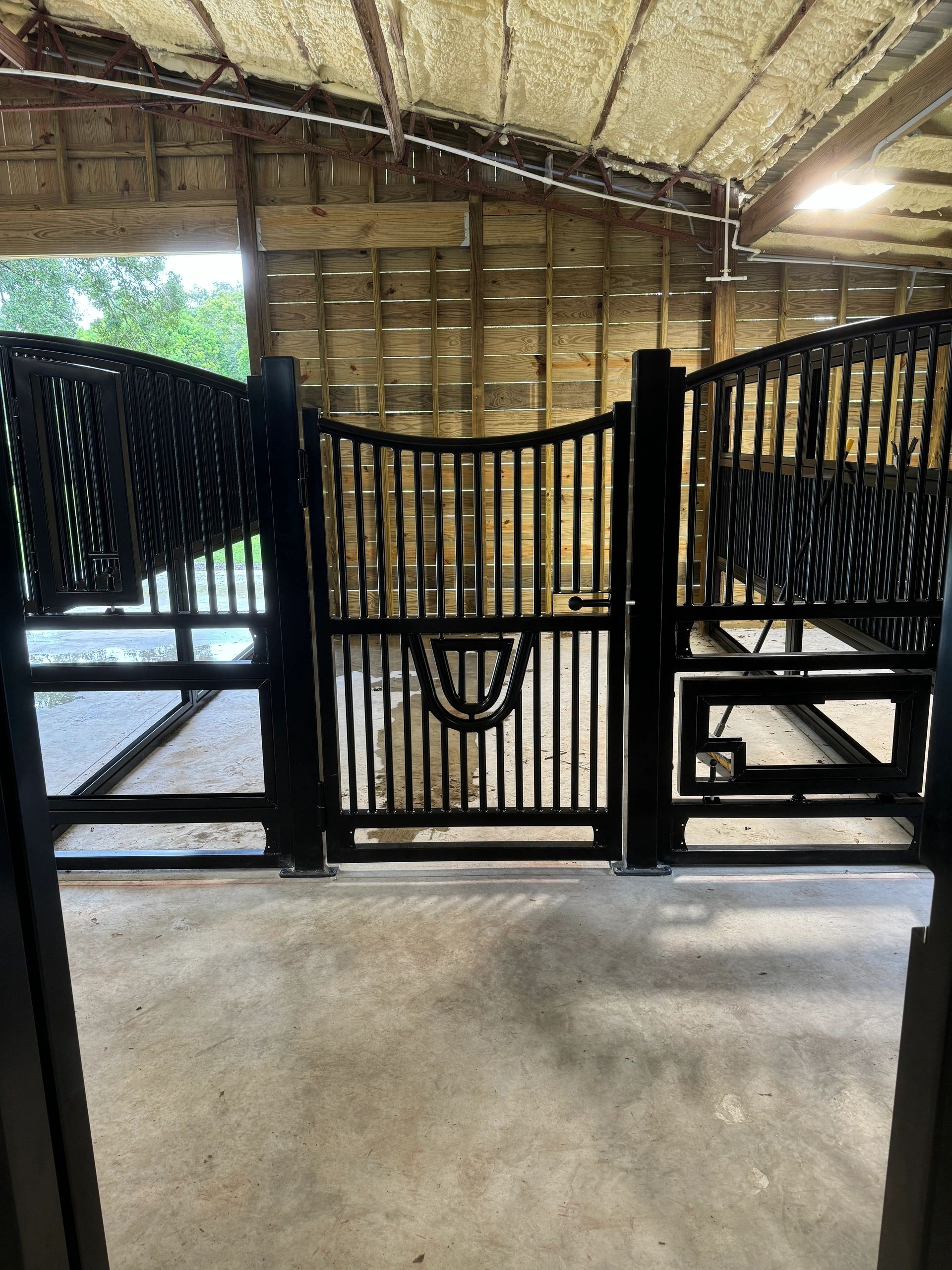 Black metal gates inside a wooden structure.