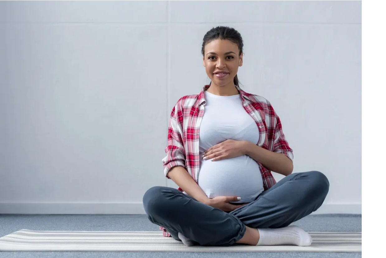 Pregnant woman holding stomach, happy she has found childbirth support for pregnancy and childbirth.