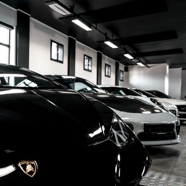 Flere luksuriøse sportsbiler parkert i en garasje.