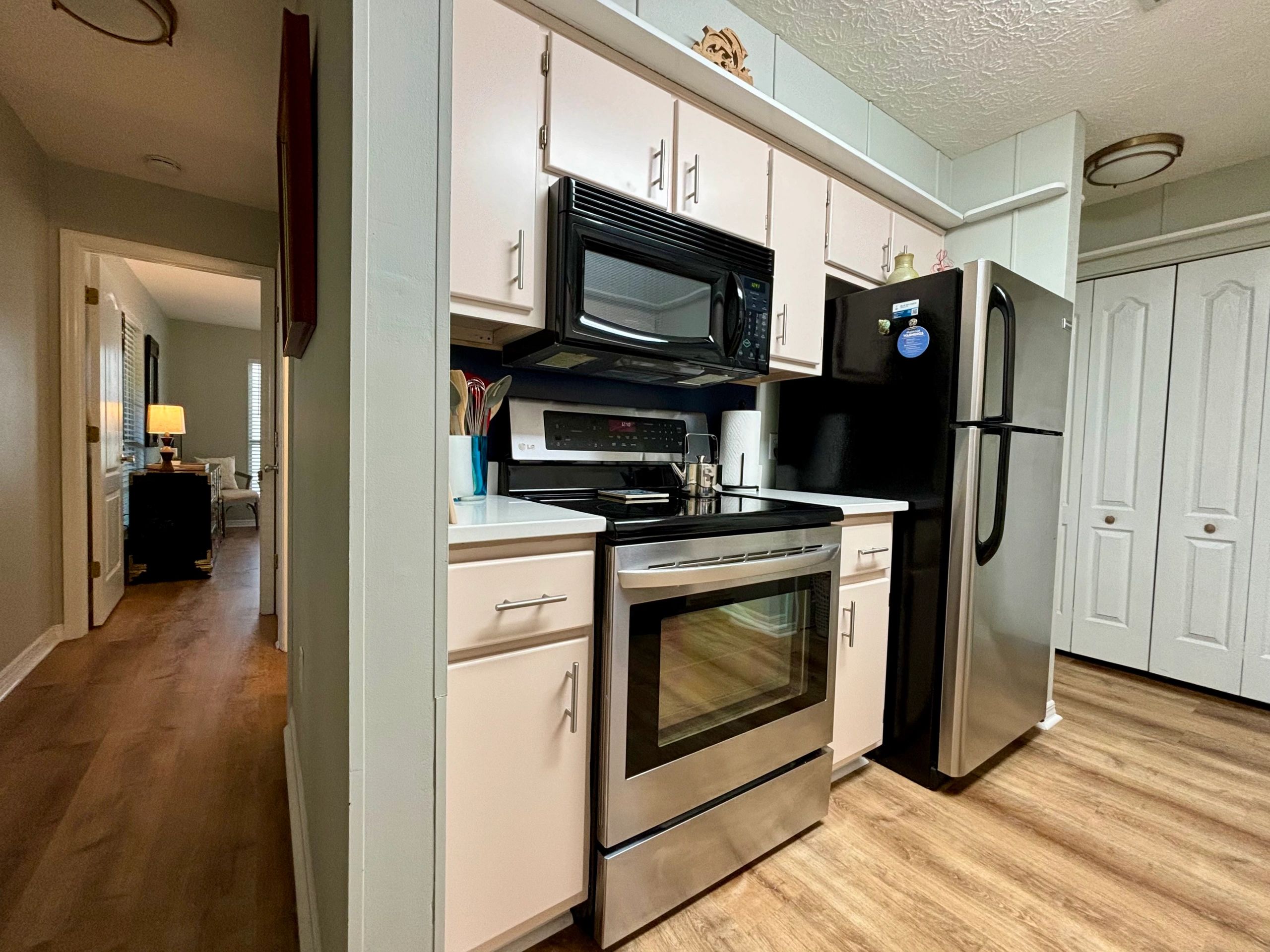 Modern kitchen with stainless steel appliances and wooden flooring.