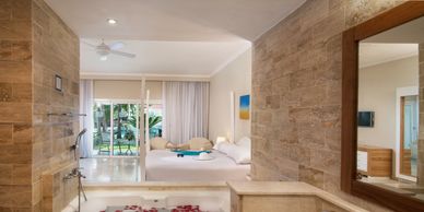 Luxurious hotel room with a large bed and tropical garden view.