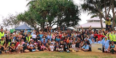 Large crowd of beach clean volunteers cheer and celebrate their efforts leading up to turtle season