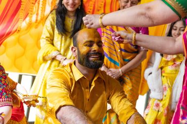 South Asian groom is smeared with turmeric paste in a Pithi Ceremony at Spillian in Fleischmanns NY