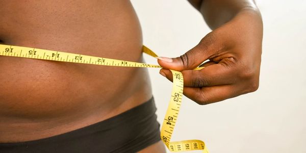 a woman measuring her waist.
