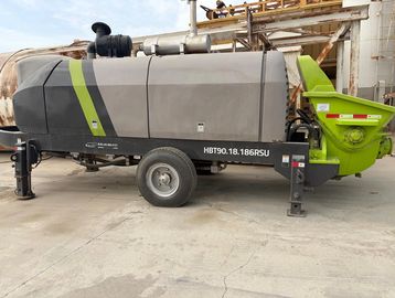 Large concrete pump machine parked on a construction site.