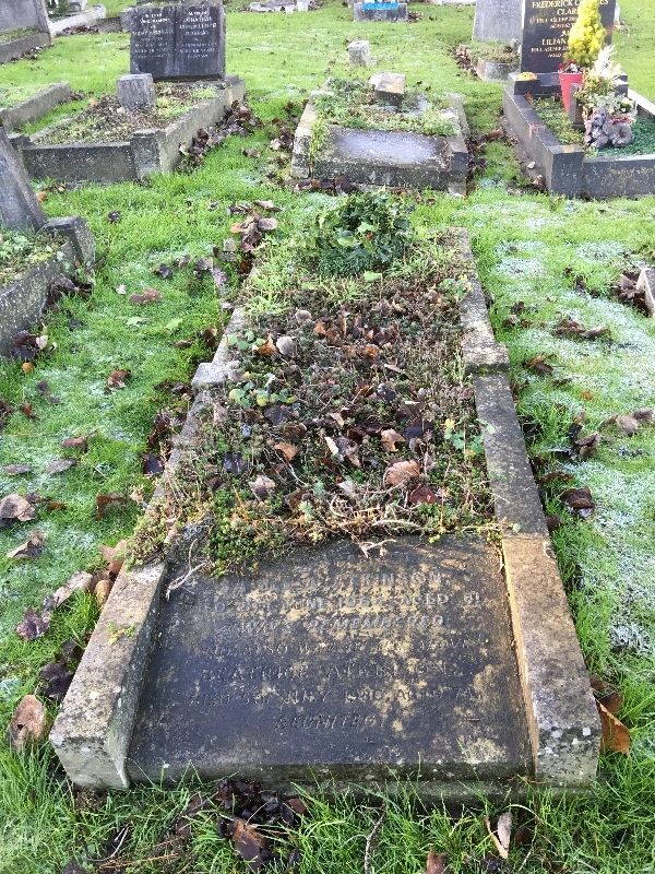 Old, weathered grave with overgrown vegetation.