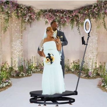 Thee 360 photo booth rental being used by the bride and groom. 