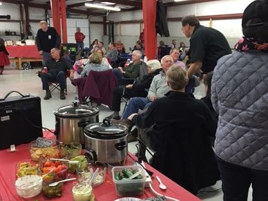 Group of people gathered indoors, engaging in conversation.