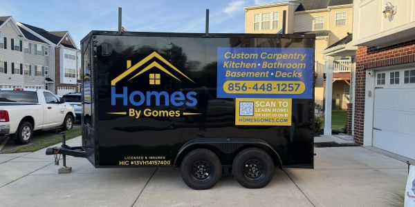 Black trailer with a carpentry business advertisement.