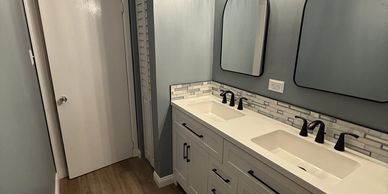 Modern bathroom with double sinks and dual mirrors.