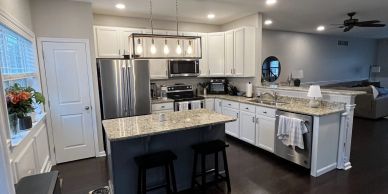Modern kitchen with white cabinets and granite countertops.