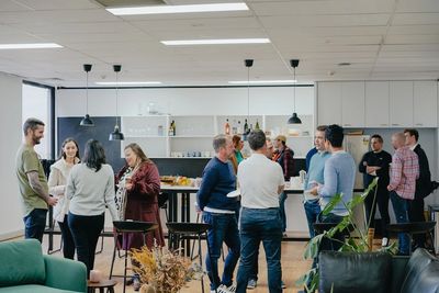 People gathering at an event. There are three different groups of people chatting 