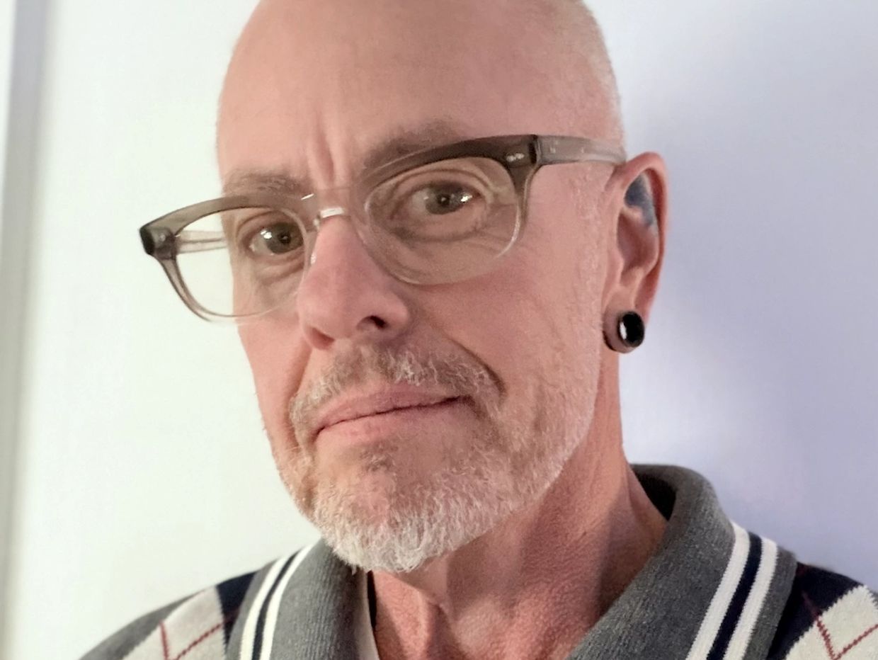 Close-up portrait of a man with glasses and a gray beard.