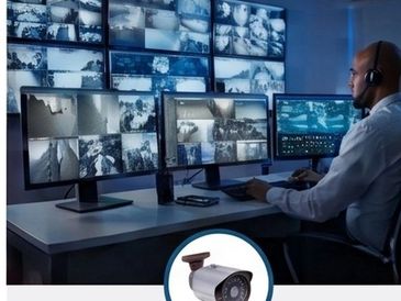 Security officer monitors multiple surveillance screens.