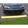 A car is parked behind a yellow parking curb in an outdoor parking space.