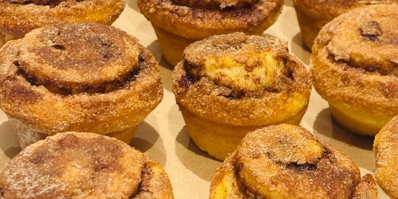 Freshly baked cinnamon sugar muffins arranged on a tray.